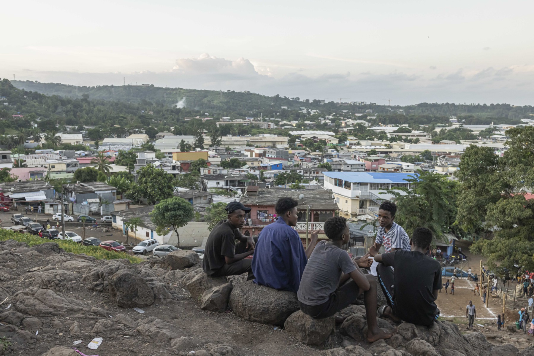 Des garçons parlent alors qu'ils sont assis sur une colline surplombant le village de Kaweni, près de Mamoudzou, sur l'île de Mayotte, le 26 avril 2023. (Photo Patrick Meinhardt / AFP)