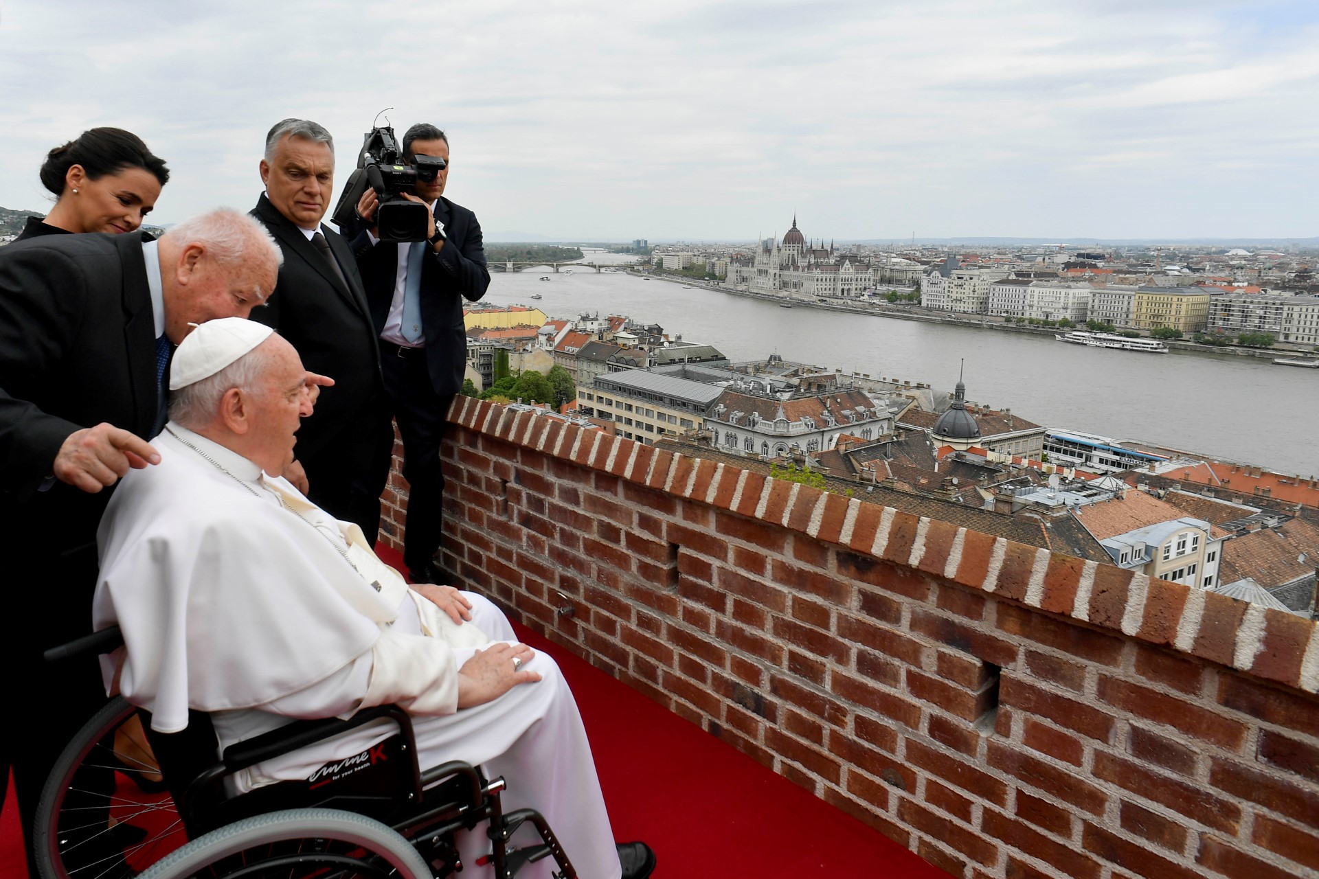 Cette photo prise et distribuée le 28 avril 2023 par les médias du Vatican montre le pape François surplombant la ville avec la présidente hongroise Katalin Novak et le Premier ministre hongrois Viktor Orban après une réunion avec les autorités, la société civile et le corps diplomatique dans l'ancien monastère des Carmélites à Budapest, en Hongrie, lors de sa deuxième visite en Hongrie en moins de deux ans. (Photo par Handout / VATICAN MEDIA / AFP