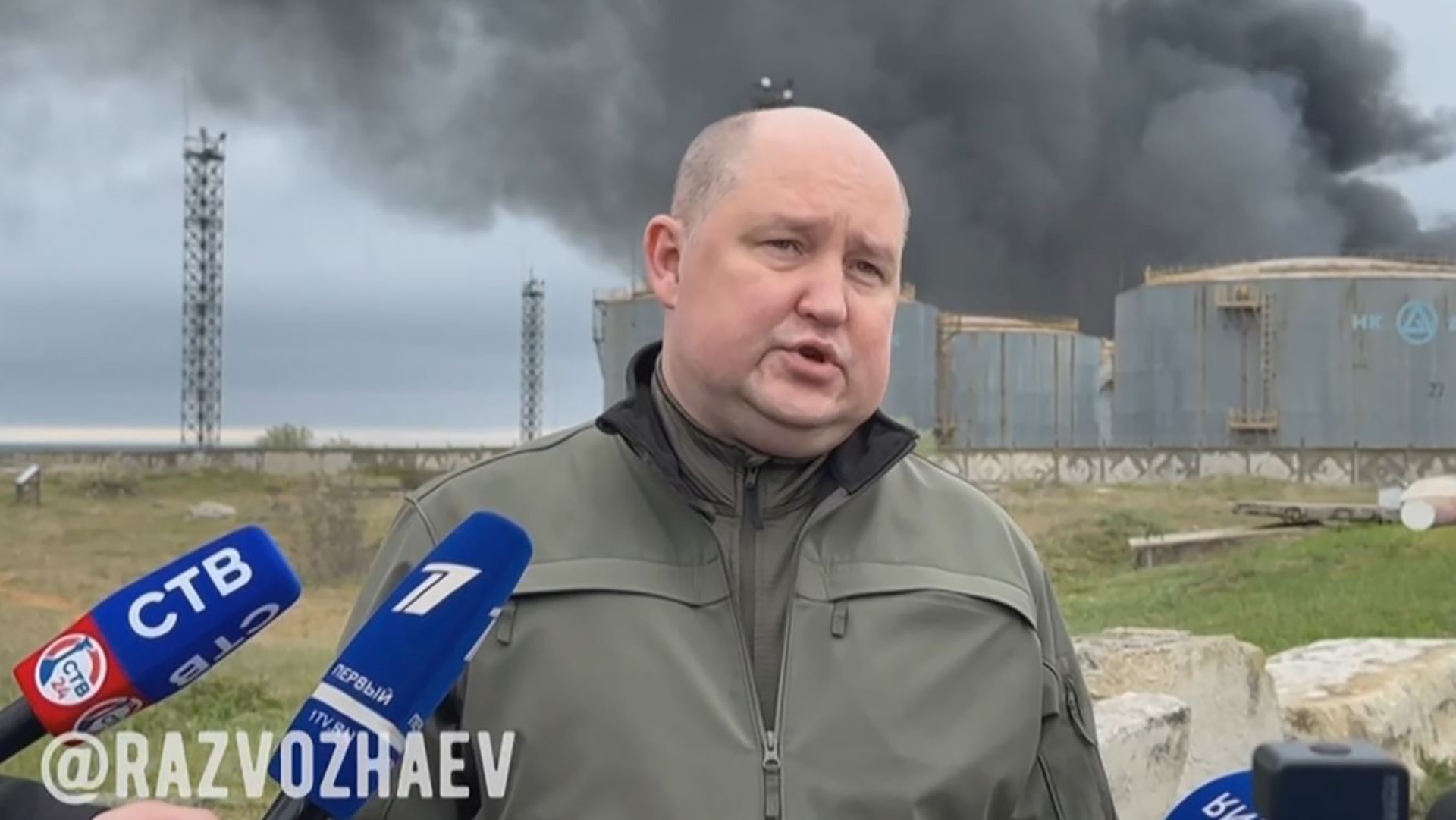 Cette vidéo extraite d'une séquence publiée le 29 avril 2023 sur la chaîne Telegram de Mikhail Razvozhayev, le gouverneur de Sébastopol installé par Moscou, montre M. Razvozhayev s'adressant à la presse alors que de la fumée noire s'échappe à l'arrière-plan d'un dépôt de carburant à Sébastopol, le principal port de la Crimée annexée par Moscou. (Photo par Telegram/ @razvozhaev / AFP)