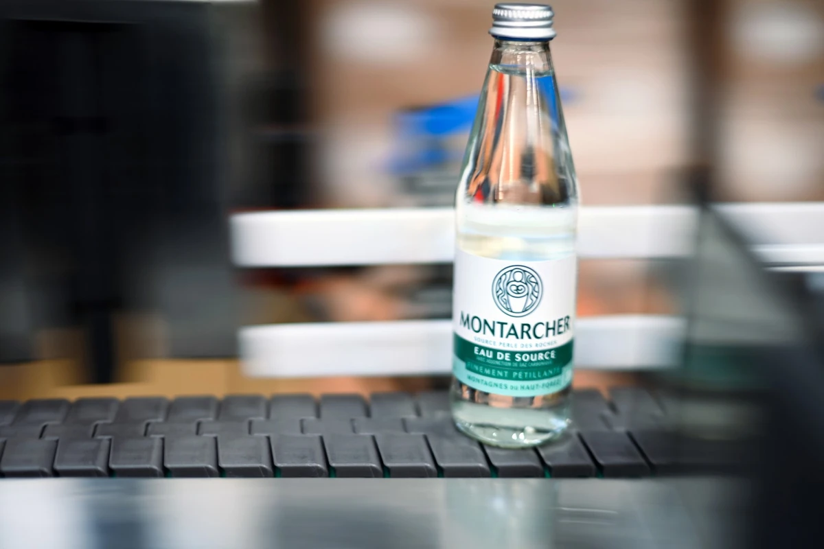 Cette photographie prise le 19 avril 2023 montre une bouteille de l'usine d'eau de source de Montarcher, dans l'est de la France. Arrêtée depuis 2018, l'exploitation commerciale de la Source des Perles, dans les monts du Forez (Loire), a été relancée en début d'année par un entrepreneur local qui mise sur l'essor du marché de l'eau en bouteille, dans un contexte mondial marqué par la raréfaction de l'or bleu. (Photo OLIVIER CHASSIGNOLE / AFP)