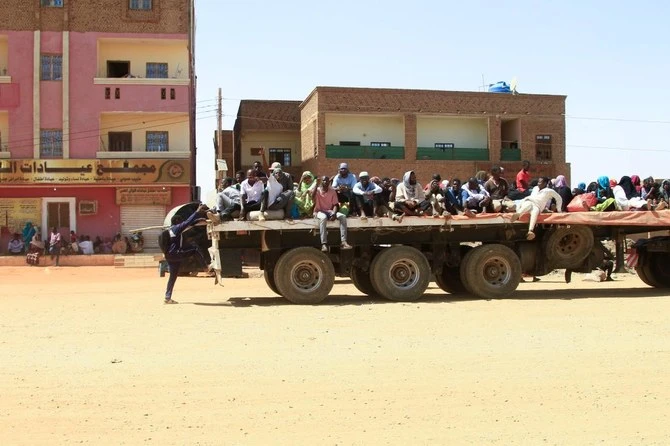 Des personnes fuyant une bataille de rue entre les forces de deux généraux soudanais rivaux sont transportées à l'arrière d'un camion dans le sud de Khartoum, le 21 avril 2023. (AFP)