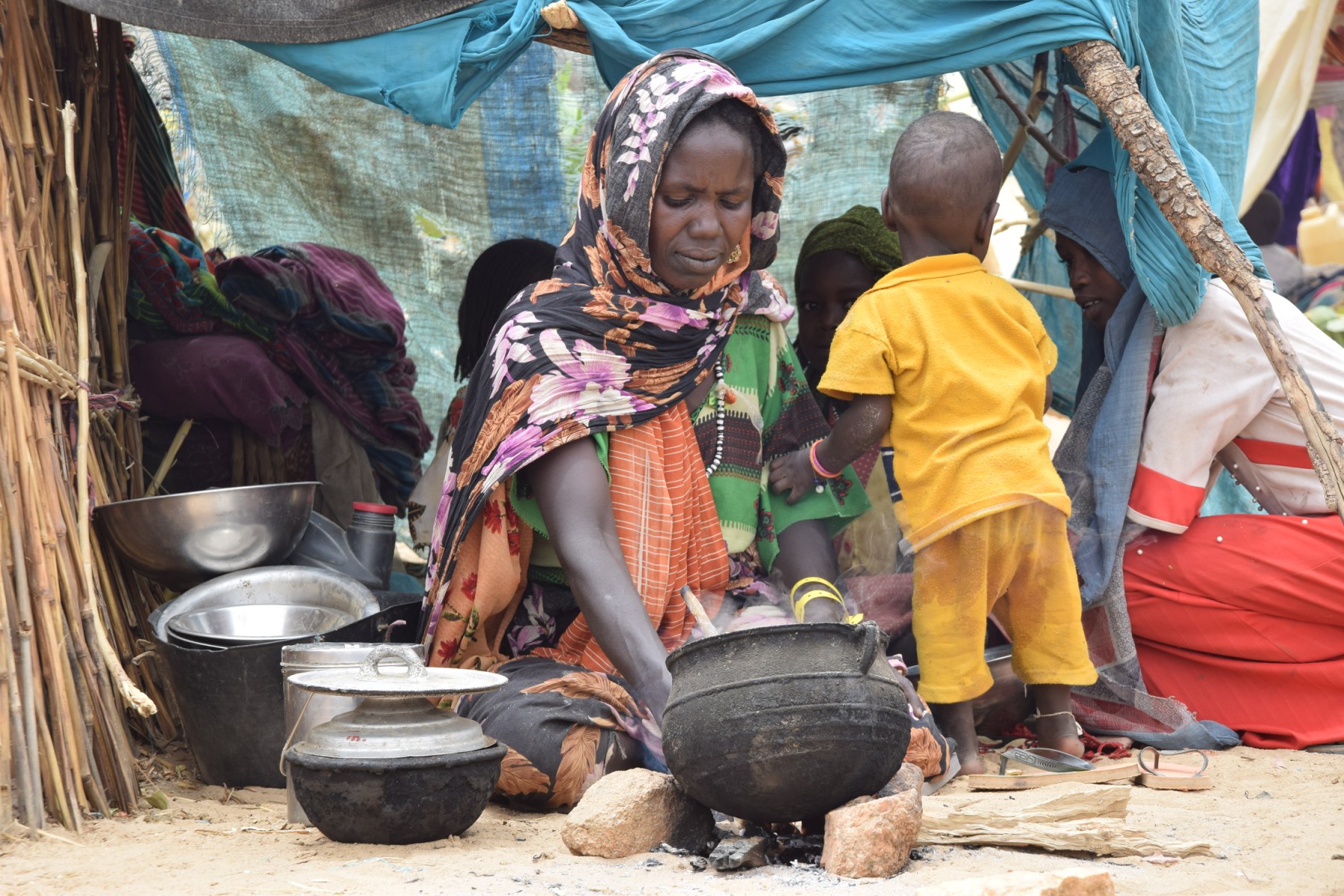 Une réfugiée soudanaise qui a traversé le Tchad prépare un repas dans un abri de fortune dans un camp à Koufroun, près d'Echbara, le 1er mai 2023. (Photo Gueipeur Denis SASSOU / AFP)