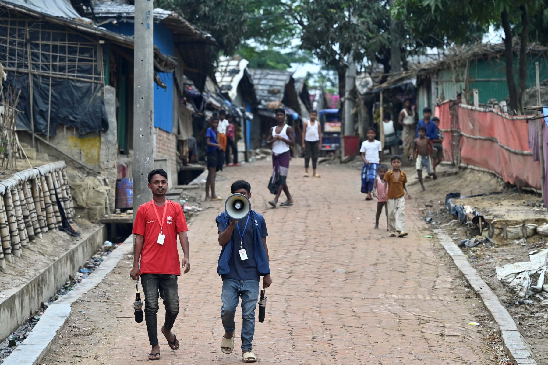 Des employés du Haut Commissariat des Nations Unies pour les réfugiés utilisent un mégaphone pour alerter le public avant l'arrivée du cyclone Mocha, dans le camp de réfugiés rohingyas de Nayapara à Teknaf, le 13 mai 2023. (Photo de Munir uz zaman / AFP)