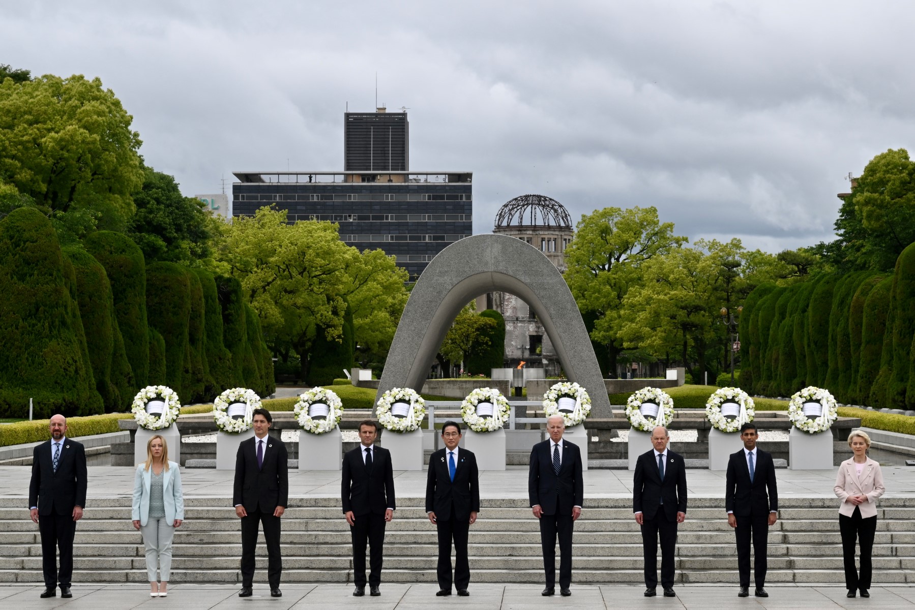 (De gauche à droite) Le président du Conseil européen Charles Michel, la Première ministre italiennne Giorgia Meloni, le Premier ministre canadien Justin Trudeau, le président français Emmanuel Macron, le Premier ministre japonais Fumio Kishida, le président américain Joe Biden, le chancelier allemand Olaf Scholz, le Premier ministre britannique Rishi Sunak et la présidente de la Commission européenne Ursula von der Leyen posent pour une photo de groupe après une cérémonie de pose de gerbe dans le cadre du sommet des dirigeants du G7 à Hiroshima, le 19 mai 2023. (Photo par Kenny HOLSTON / POOL / AFP)