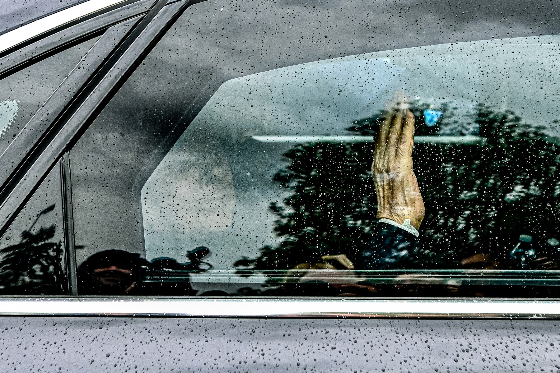 L'ancien premier ministre italien Silvio Berlusconi salue de l'intérieur de sa voiture alors qu'il quitte le 19 mai 2023 l'hôpital San Raffaele de Milan après sa sortie de l'hôpital de Milan. (Photo de Piero Cruciatti / AFP)