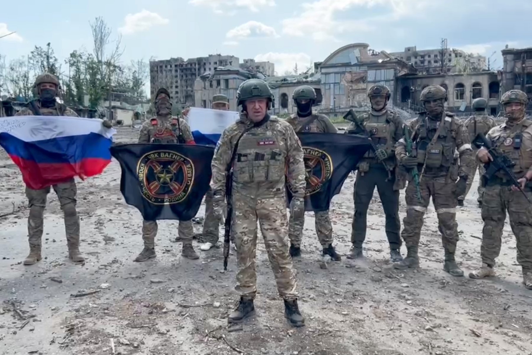 Cette capture d’écran extraite d'un document diffusé le 20 mai 2023 sur le compte Telegram du service de presse de Concord - une société liée au chef du groupe mercenaire russe Wagner, Evgeniy Prigozhin - montre Evgeniy Prigozhin tenant un drapeau national russe devant ses soldats tenant les drapeaux du groupe Wagner à Bakhmut. (Photo par Handout / diverses sources)