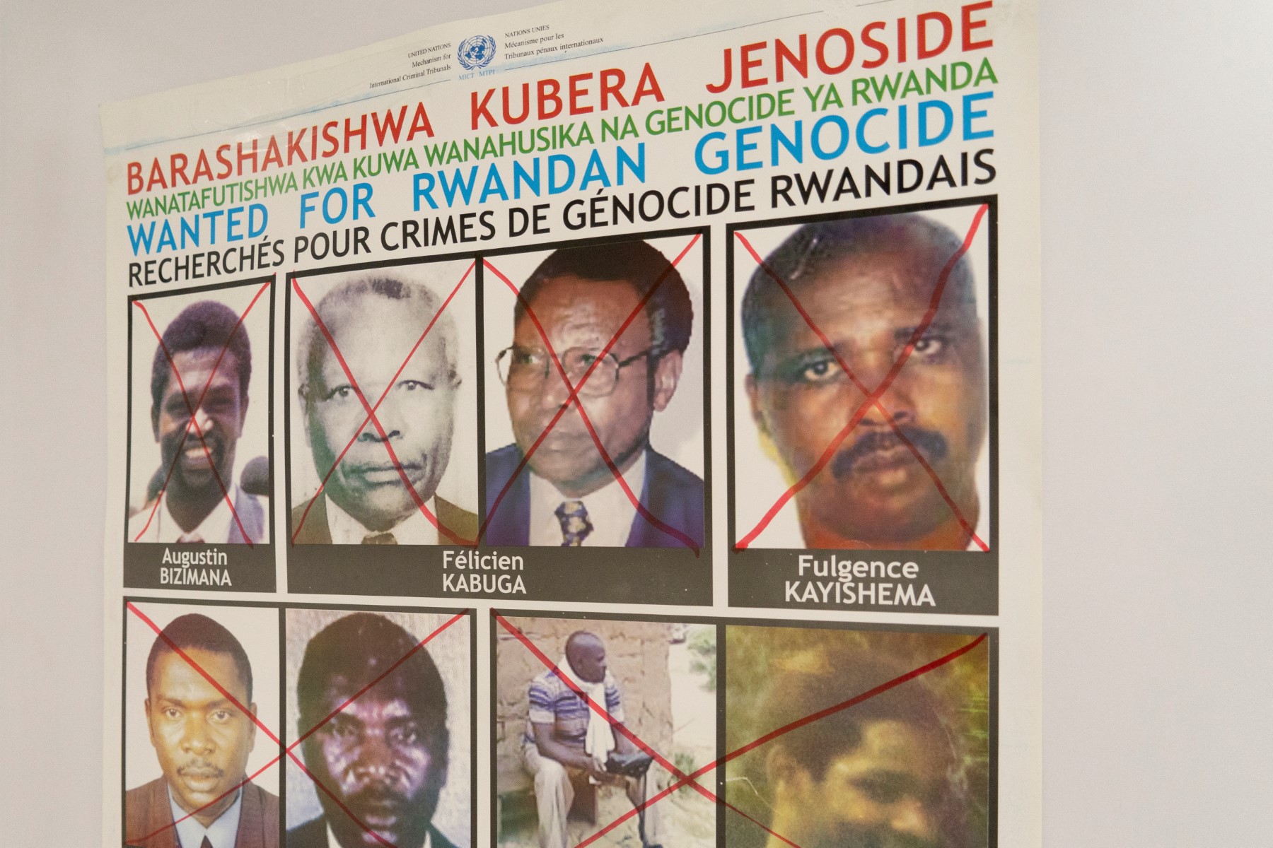Fulgence Kayishema (rangée supérieure à droite) est vu sur un avis de recherche accroché au mur du bureau de la Cellule de recherche des fugitifs du génocide, à Gishushu, à Kigali, le 25 mai 2023. Fulgence Kayishema, l'un des quatre derniers fugitifs recherchés pour leur rôle dans le génocide rwandais de 1994, a été arrêté en Afrique du Sud, ont déclaré les enquêteurs de l'ONU le 25 mai 2023. (Photo par Mariam KONE / AFP)