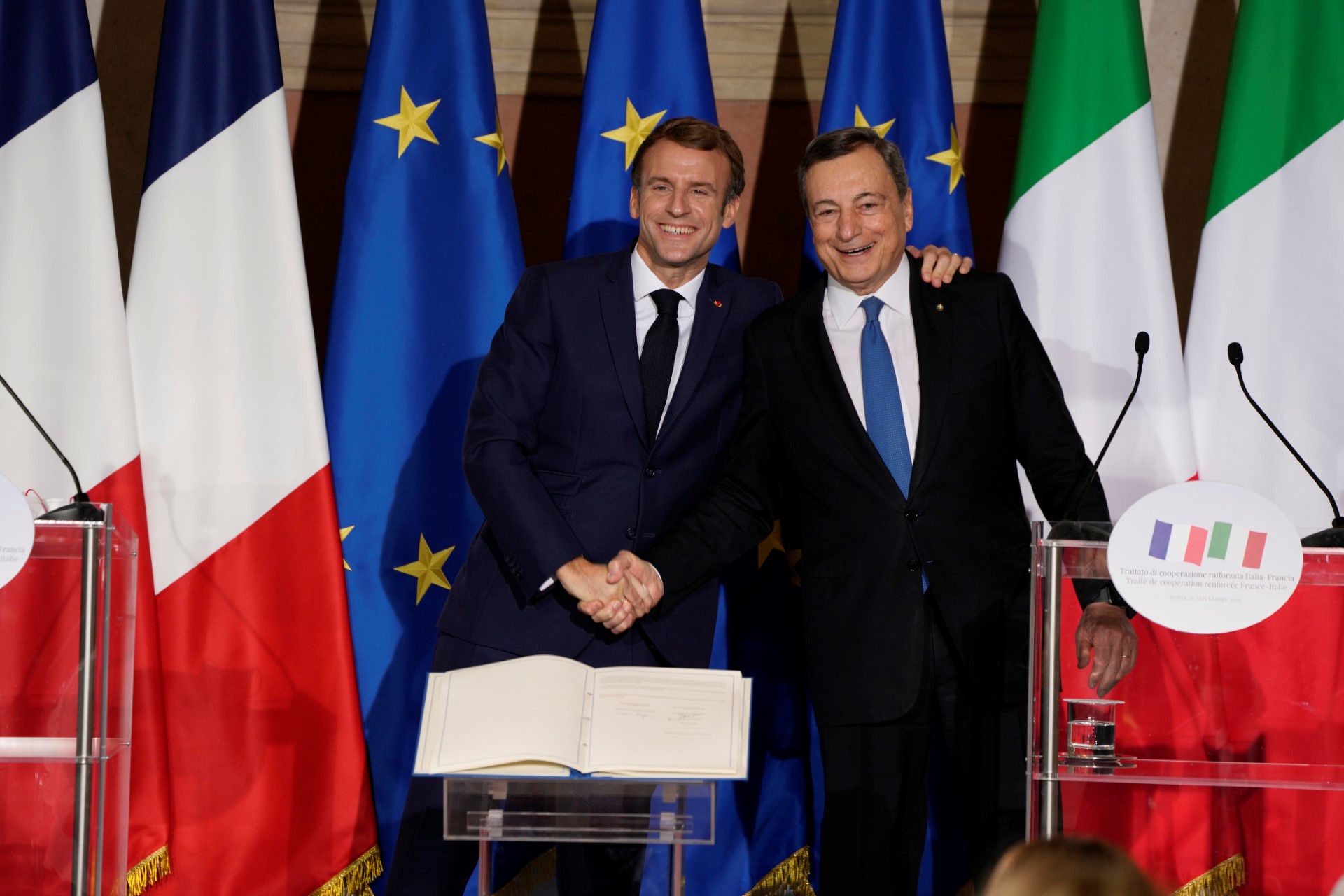 Le président français Emmanuel Macron (à gauche) et le Premier ministre italien Mario Draghi se serrent la main lors d'une conférence de presse conjointe après la signature du traité du Quirinal entre l'Italie et la France, qui vise à fournir un cadre stable et formalisé pour la coopération dans les relations entre les deux pays, à la Villa Madama à Rome, le 26 novembre 2021. (Photo Domenico Stinellis / POOL / AFP)