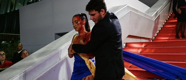 Cannes: Une femme vêtue aux couleurs de l'Ukraine se recouvre de faux sang sur le tapis rouge