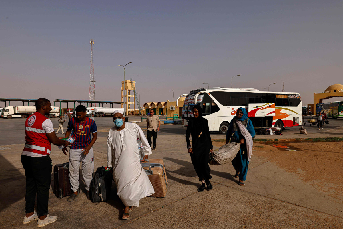 Des passagers fuyant le Soudan touché par la guerre entrent en Égypte par le port terrestre d’Argeen le 12 mai 2023. (AFP)