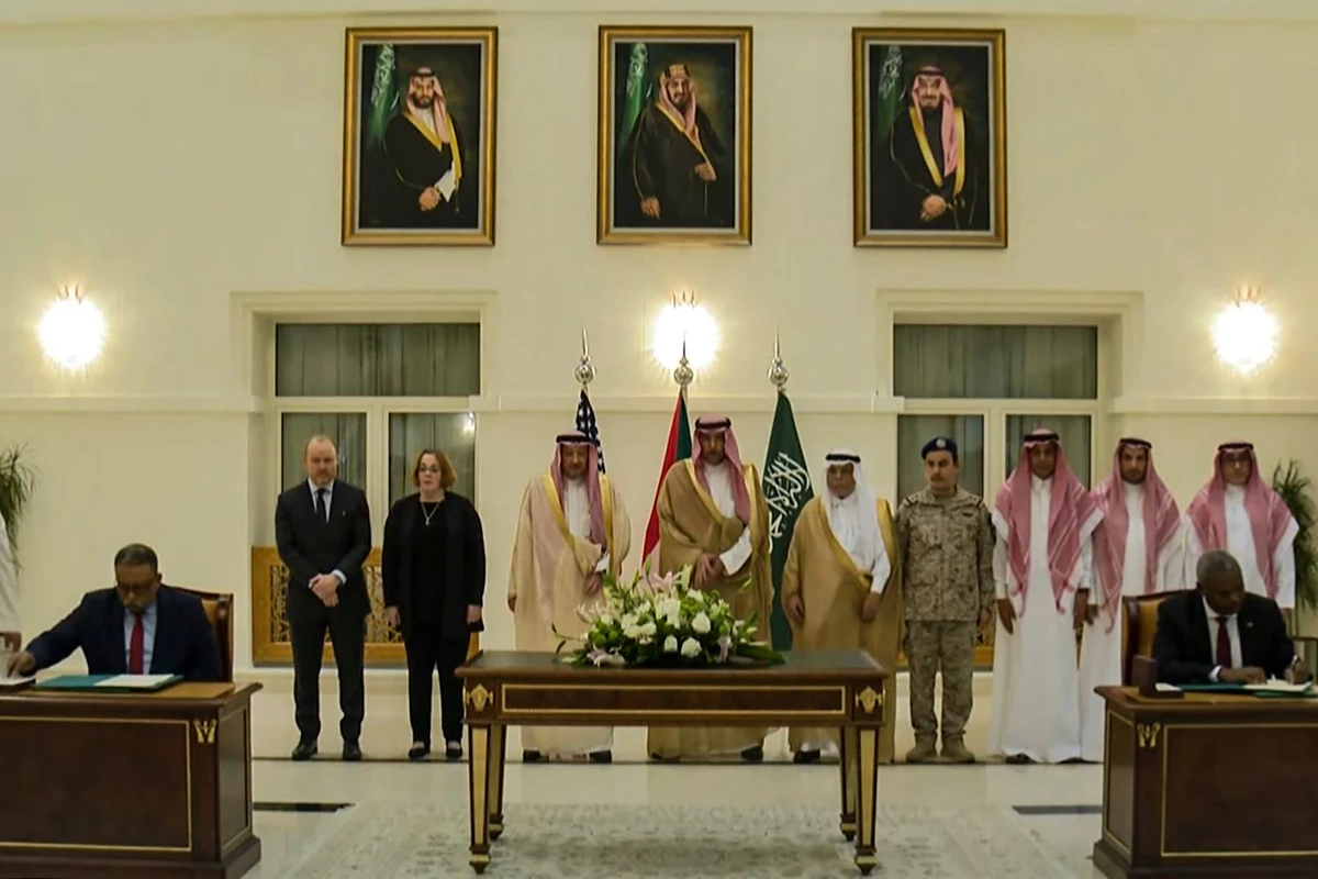 Cette capture d'écran de la chaîne de télévision saoudienne Al-Ekhbariya montre des représentants de l'armée soudanaise et des forces paramilitaires de soutien rapide (RSF) signant un accord à Jeddah, le 11 mai 2023. (Photo AL-EKHBARIYA / AFP)