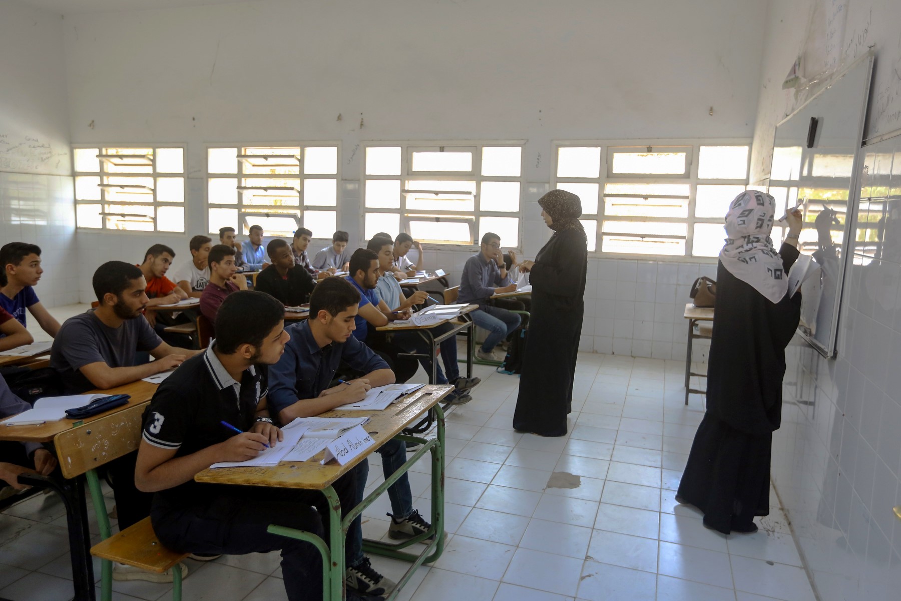 Des étudiants libyens déplacés des zones d'affrontements entre l'Armée nationale libyenne autoproclamée de Haftar et les forces loyales au gouvernement d'unité, assistent à un cours dans une école à la périphérie sud de la capitale Tripoli, le 20 mai 2019. (Mahmud TURKIA, AFP)