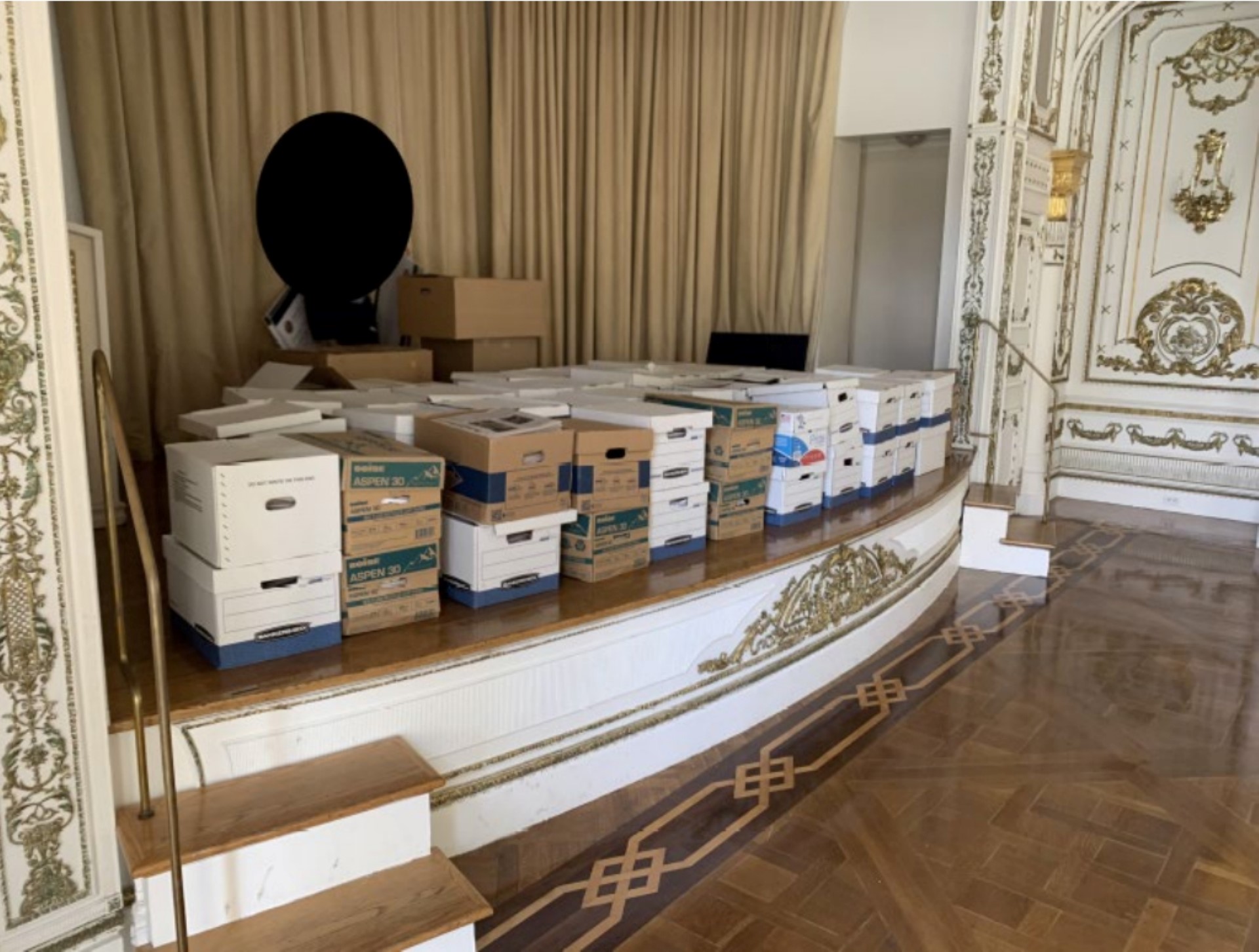 Cette image non datée, publiée par le tribunal du district sud de Floride, jointe comme preuve à l'acte d'accusation contre l'ancien président américain Donald Trump, montre des piles de boîtes prétendument stockées sur la scène de la salle de bal White and Gold à Mar-a-Lago, le club privé de l'ancien président. (Photo by Handout / US Department Of Justice / AFP).
