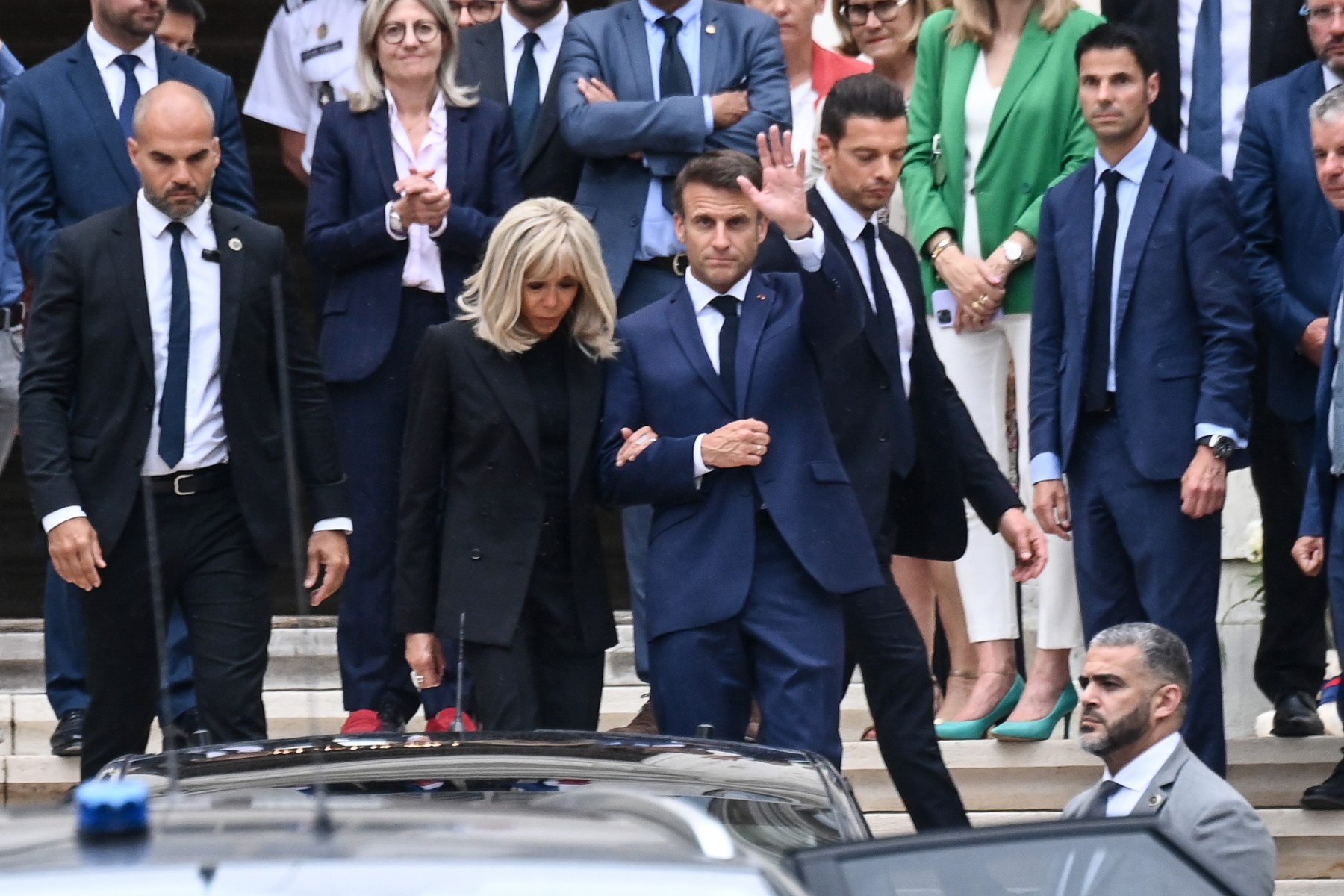 Le président français Emmanuel Macron (à droite), accompagné de la première dame Brigitte Macron (à gauche), salue la préfecture de Haute-Savoie après avoir rencontré les forces de secours à la préfecture de Haute-Savoie, au lendemain d'une attaque massive au couteau dans un parc, à Annecy, dans les Alpes françaises, en France, le 9 juin 2023. (Photo OLIVIER CHASSIGNOLE / AFP)