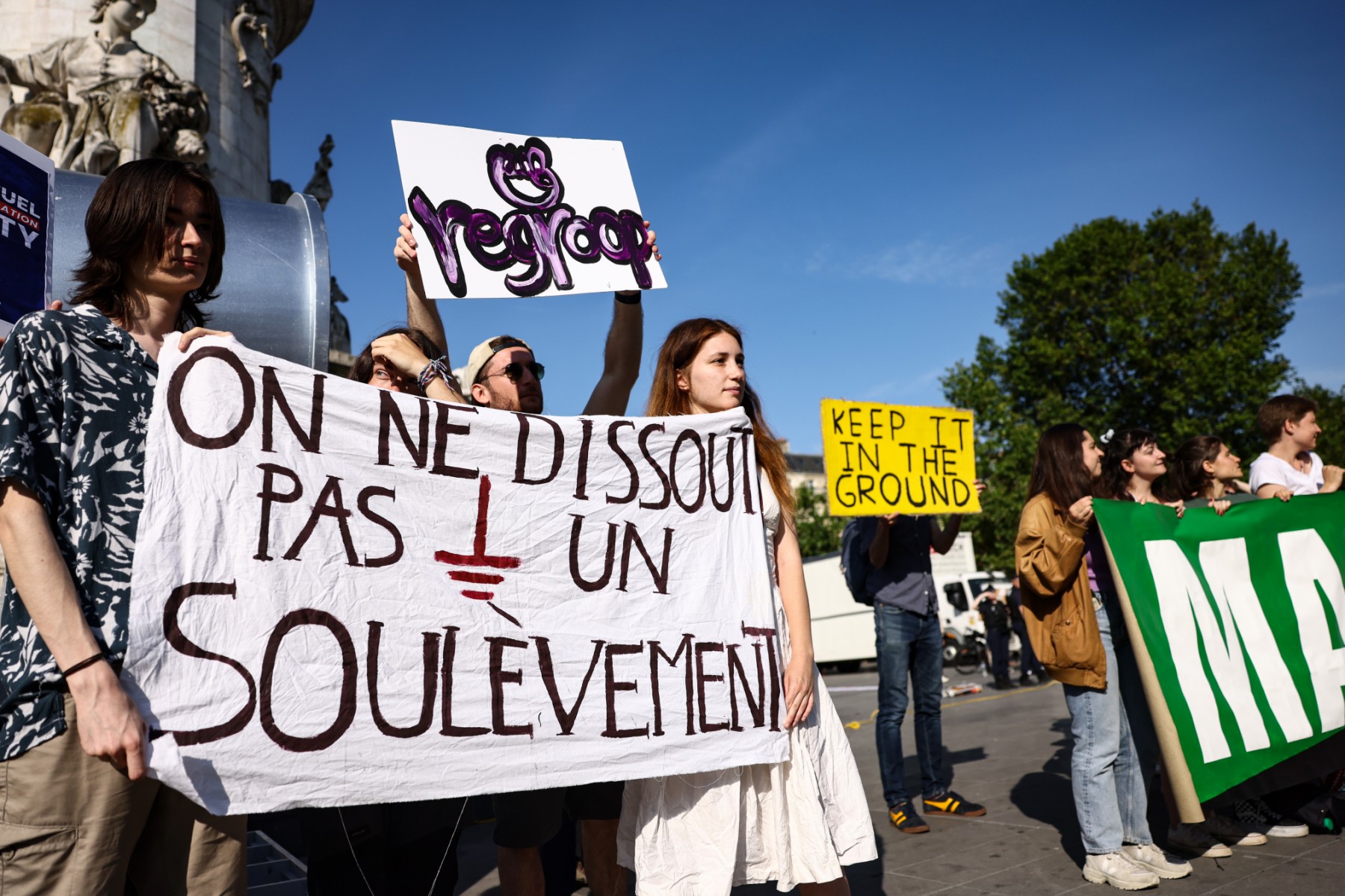 Des manifestants tiennent une banderole sur laquelle on peut lire "On ne peut pas démanteler un soulèvement" alors qu'ils manifestent contre les énergies fossiles et pour le climat, et en soutien au mouvement environnemental "Les Soulevements de la Terre" officiellement déclaré dissous par le gouvernement français, place de la République en marge du sommet du Nouveau Pacte Financier Mondial, à Paris, le 23 juin 2023. (Photo par Thomas SAMSON / AFP)