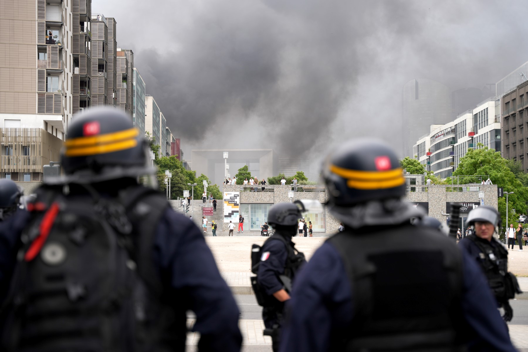 Des CRS font face à des manifestants, avec la Grande Arche de la Défense en arrière-plan, à la fin d'une marche commémorative pour un adolescent abattu par un policier, dans la banlieue parisienne de Nanterre, le 29 juin 2023. (Photo Zakaria ABDELKAFI / AFP)