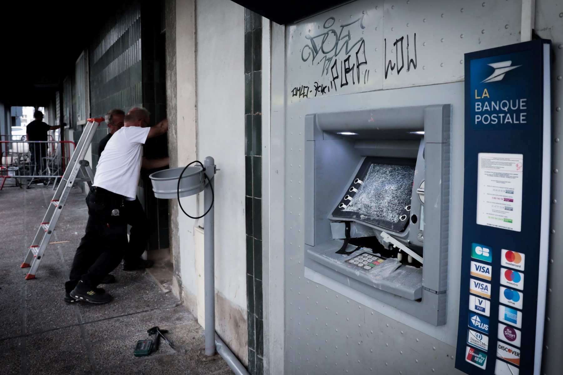 Des ouvriers réparent un bureau de poste endommagé à Rouen, dans le quartier de Chatelet, dans le nord-ouest de la France, le 29 juin 2023. (Photo LOU BENOIST / AFP)