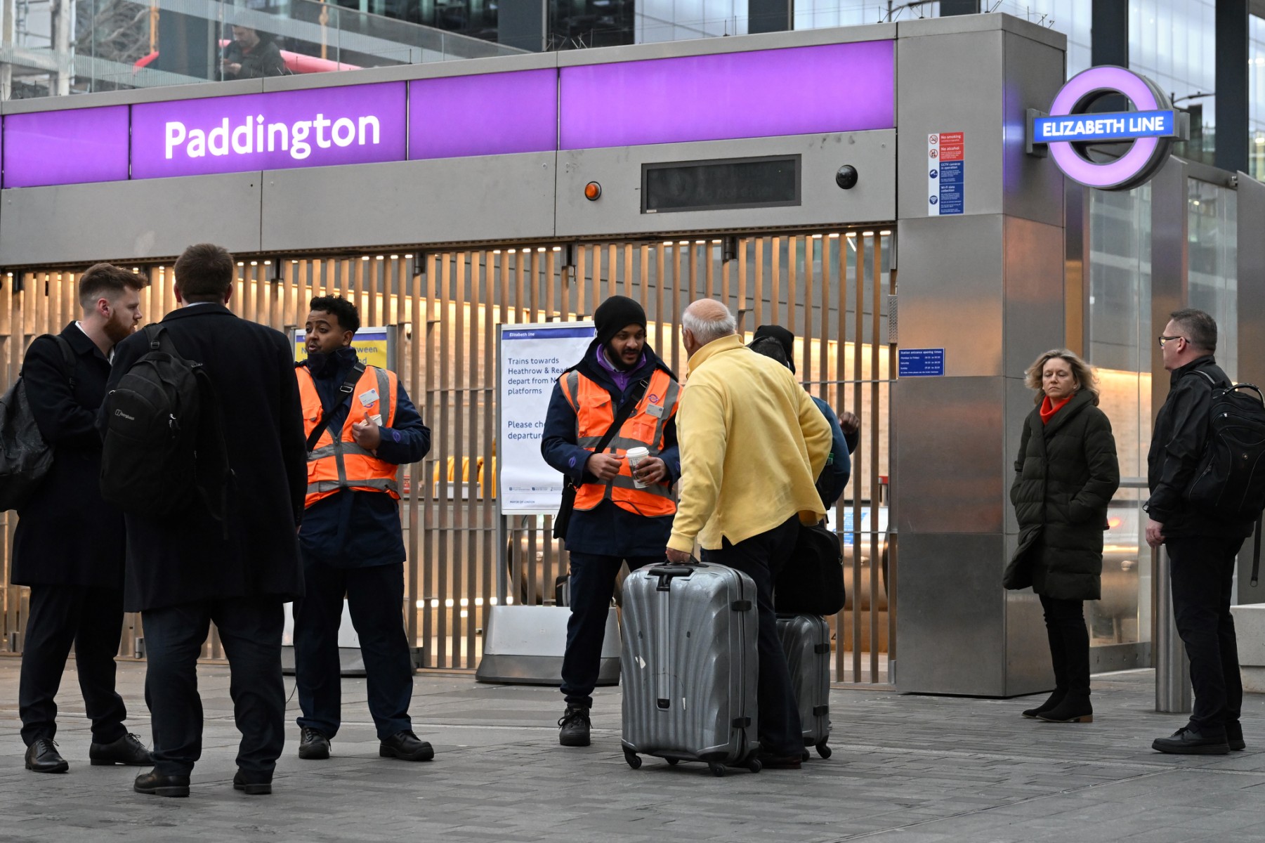 Des voyageurs discutent avec des membres du personnel alors que des barrières bloquent l'entrée de la ligne Elizabeth à la gare de Paddington à Londres, le 12 janvier 2023, dans le cadre d'une nouvelle grève des travailleurs du rail. (Photo Justin Tallis / AFP)