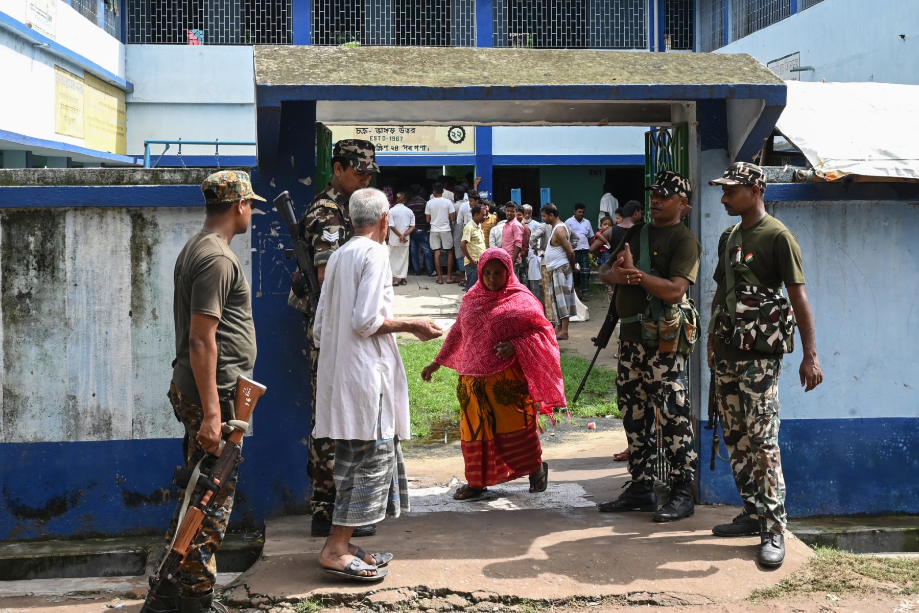 Des paramilitaires montent la garde à l'entrée d'un bureau de vote lors des élections locales (Panchayat) au Bengale occidental, dans la banlieue de Kolkata, le 8 juillet 2023. (Photo DIBYANGSHU SARKAR / AFP)