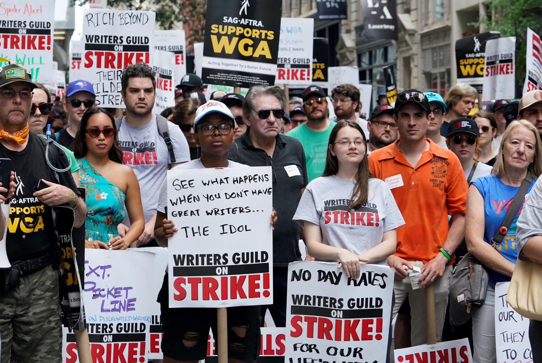 Des membres de la Writers Guild of America et de la Screen Actors Guild posent pour une photo lors d'un piquet de grève devant Warner Bros. à New York, le 13 juillet 2023. (Photo par TIMOTHY A. CLARY / AFP)