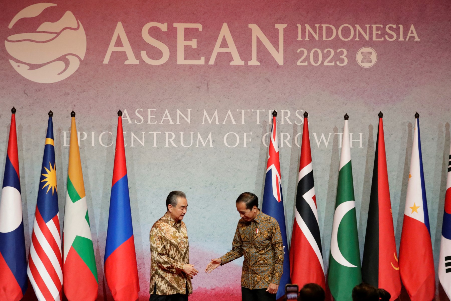 Le président indonésien Joko Widodo salue le directeur du Bureau de la Commission des affaires étrangères du Comité central du Parti communiste chinois Wang Yi (à gauche) lors de la visite de courtoisie à la réunion des ministres des Affaires étrangères de l'Association des nations de l'Asie du Sud-Est (ASEAN) à Jakarta, le 14 juillet 2023. (Photo par AJENG DINAR ULFIANA / POOL / AFP)