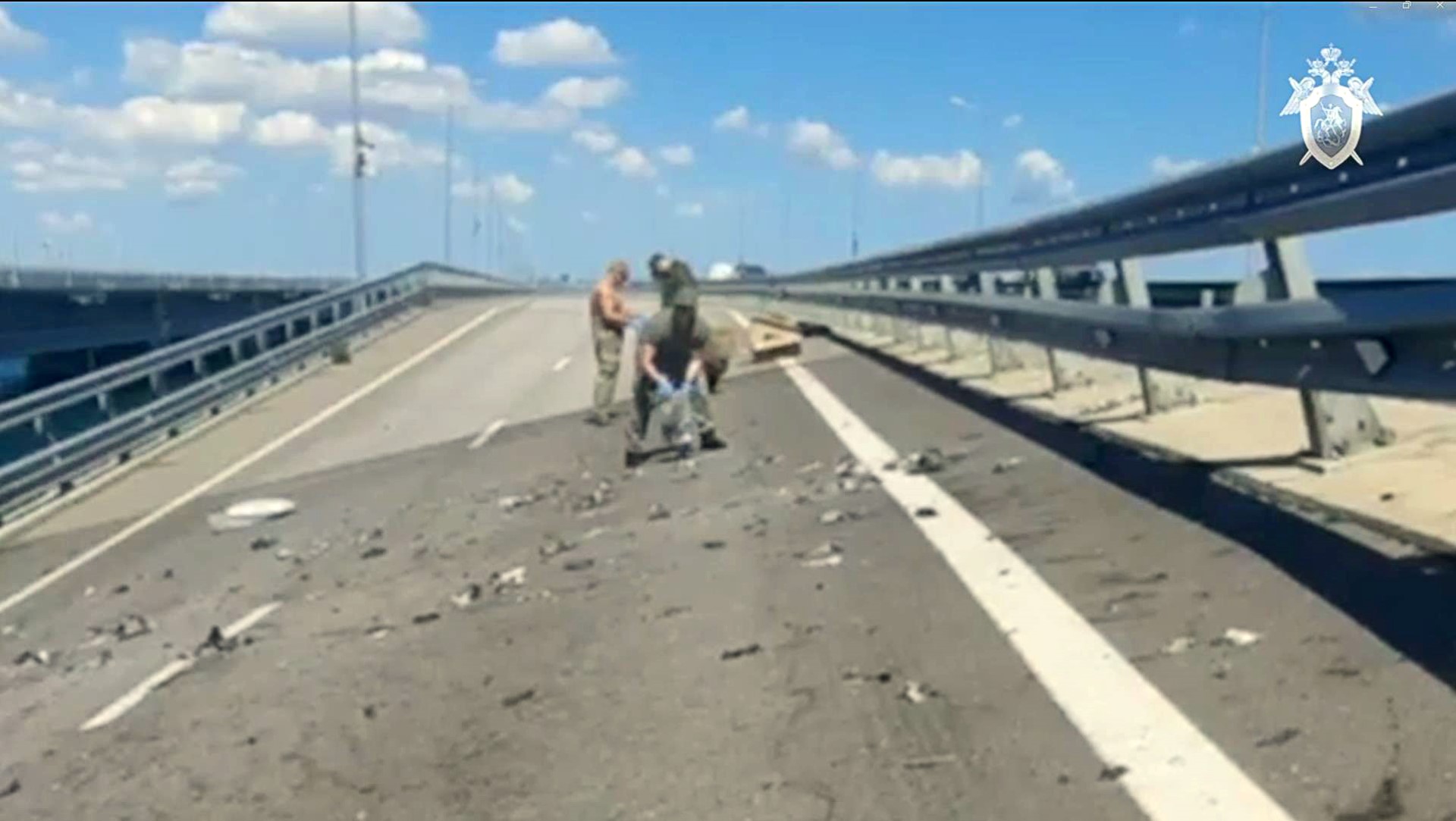 Cette capture de vidéo prise et publiée le 17 juillet 2023 par le Comité d'enquête russe montre des enquêteurs du comité travaillant sur le pont de Kertch - reliant la Crimée à la Russie - qui a été fortement endommagé à la suite d'une attaque.. (Photo par Russian Investigative Committee / AFP)
