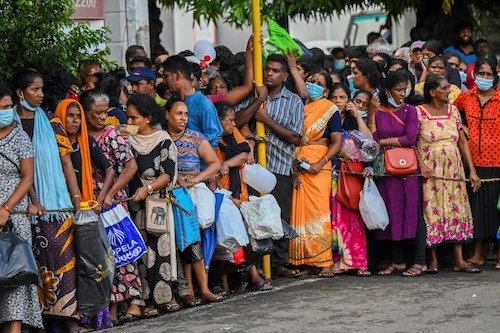 Des personnes font la queue pour acheter du kérosène à usage domestique dans une station d'approvisionnement à Colombo le 26 mai 2022. (Photo par ISHARA S. KODIKARA / AFP)