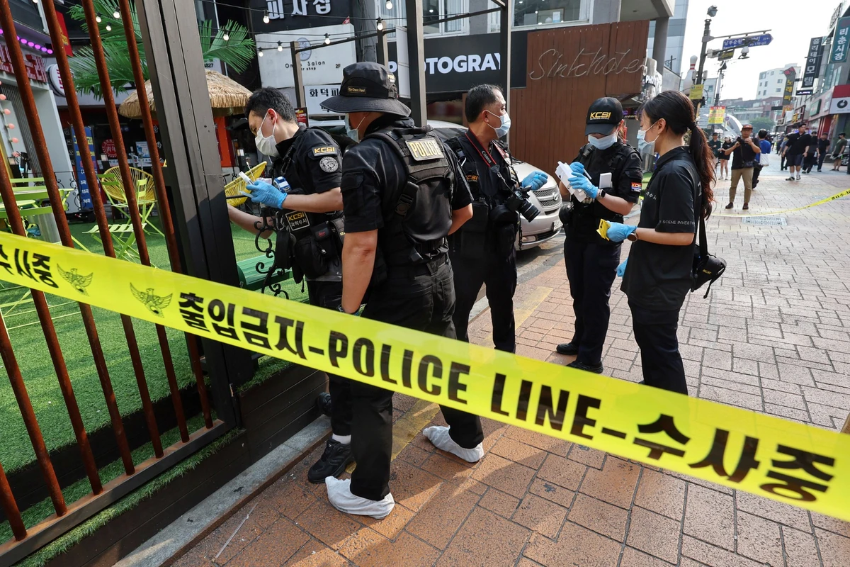 Des policiers enquêtent sur les lieux d'une attaque près de la station de métro Sillim dans le sud-ouest de Séoul, le 21 juillet 2023. (Photo by YONHAP / AFP)