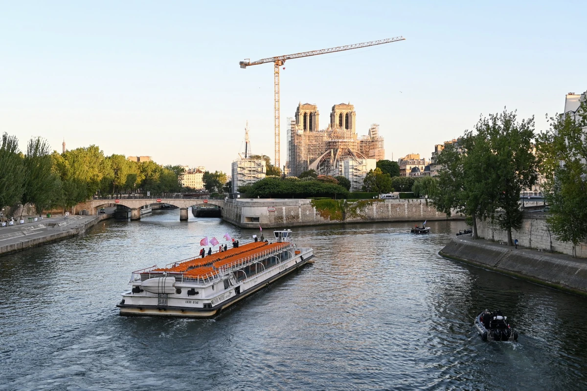 Une péniche navigue vers la cathédrale Notre Dame de Paris sur la Seine le 17 juillet 2023, lors d'une parade pour tester les "manœuvres", les "distances", la "durée" et la "captation vidéo" de la future cérémonie d'ouverture des Jeux Olympiques de Paris en 2024. (Photo Bertrand GUAY / AFP)