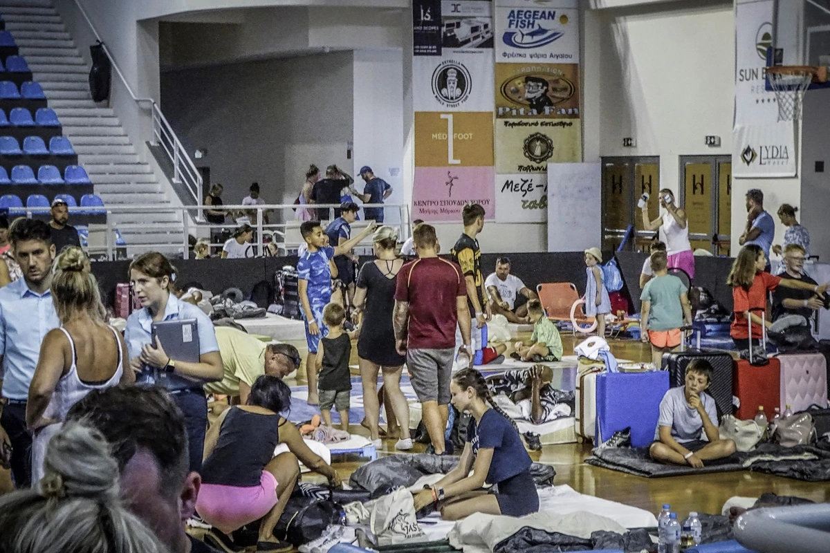 Des touristes ont passé leur nuit dans une salle de basket-ball en raison de l'incendie de forêt à Rhodes, sur l'île grecque de Rhodes, le 23 juillet 2023. (Photo par STRINGER / Eurokinissi / AFP)