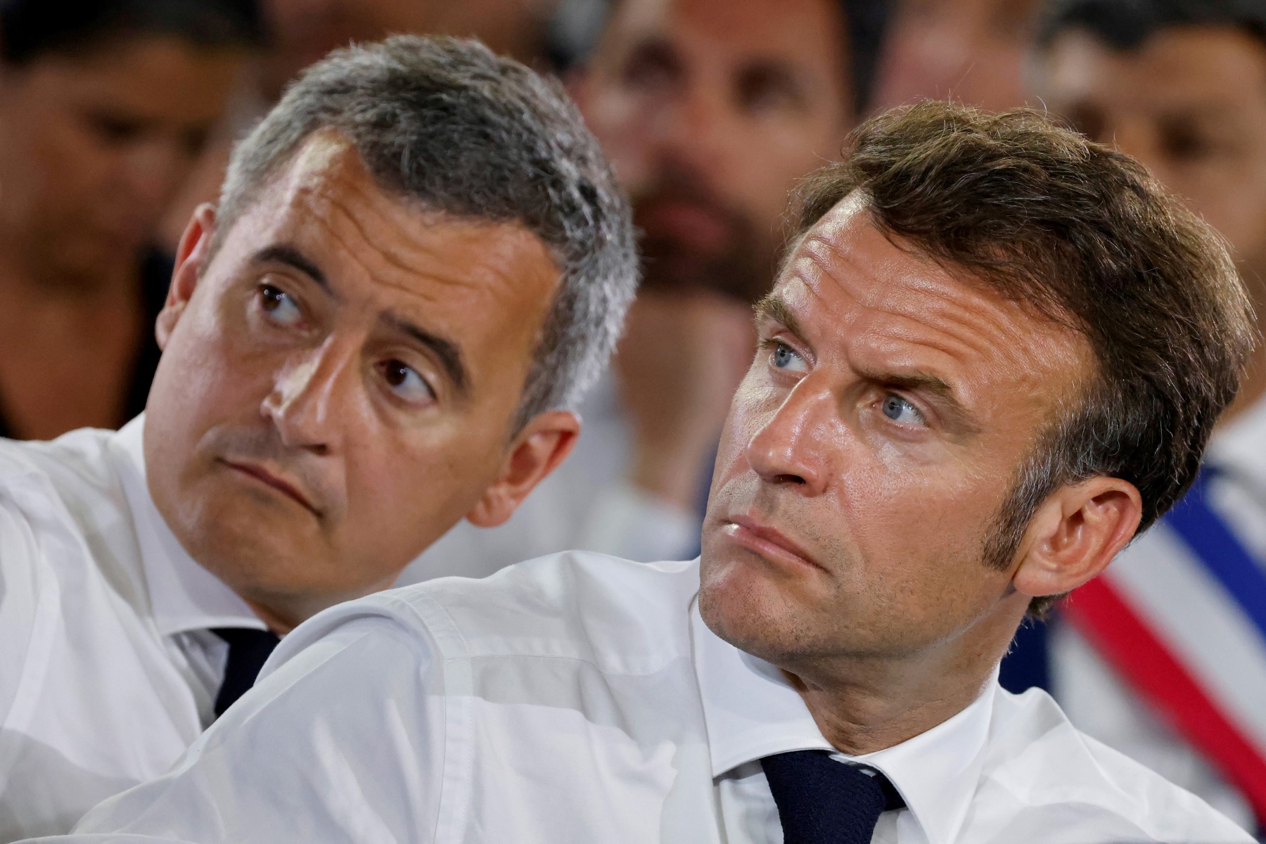 Le président français Emmanuel Macron (à droite) et le ministre français de l'Intérieur Gerald Darmanin écoutent un participant alors qu'ils assistent à une réunion publique avec des habitants dans un gymnase du quartier de La Busserine lors d'une visite à Marseille, dans le sud-est de la France, le 26 juin 2023. (Photo Ludovic Marin / POOL / AFP)
