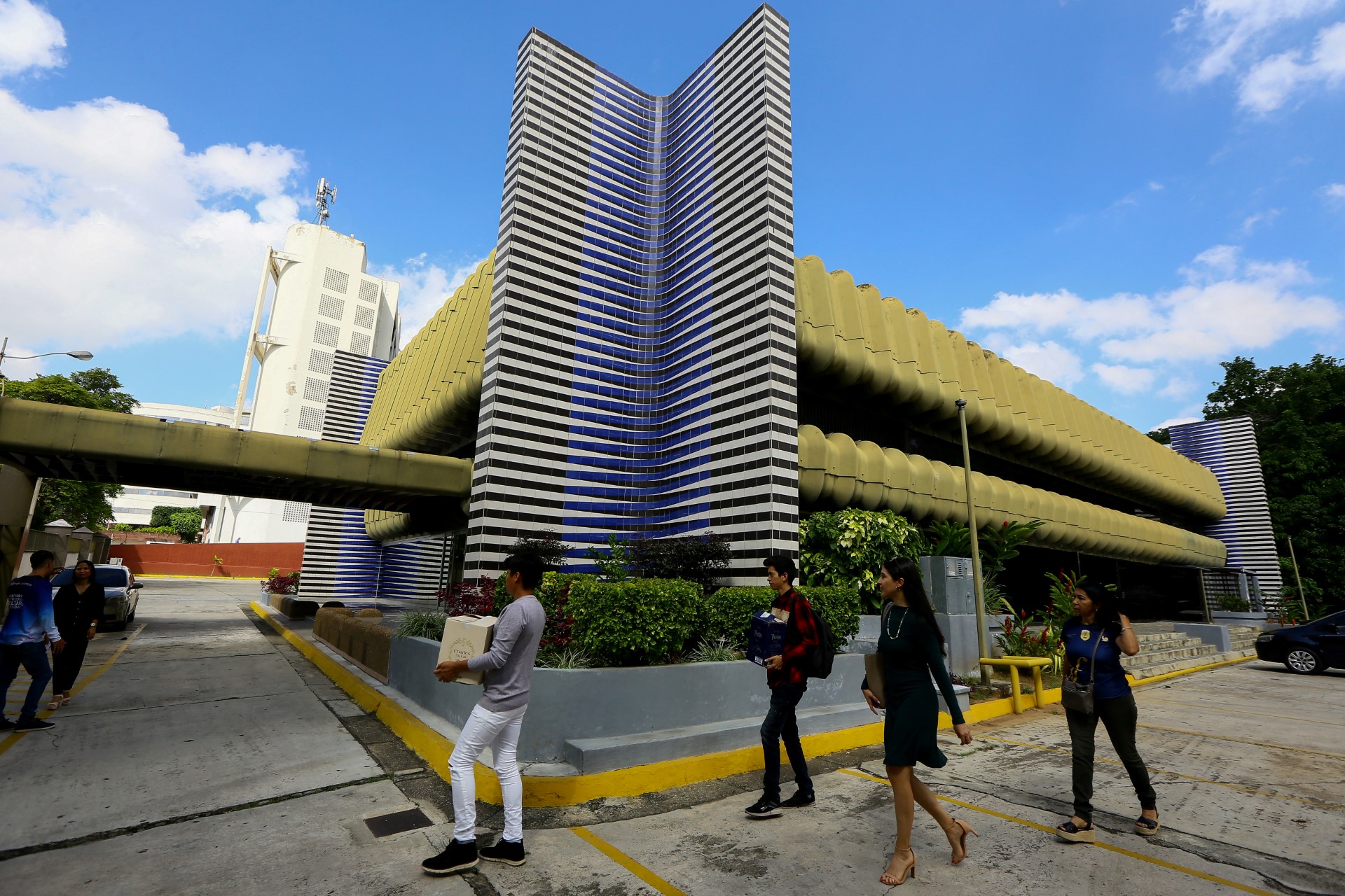 Des gens passent devant la sculpture "Induccion al Amarillo", de l'artiste vénézuélien Carlos Cruz-Diez, lors de la visite de la Fondation Mas Valencia pour commémorer le centenaire de l'artiste à Valencia, État de Carabobo, Venezuela, le 17 août 2023. (Photo de Juan Carlos Hernandez / AFP)