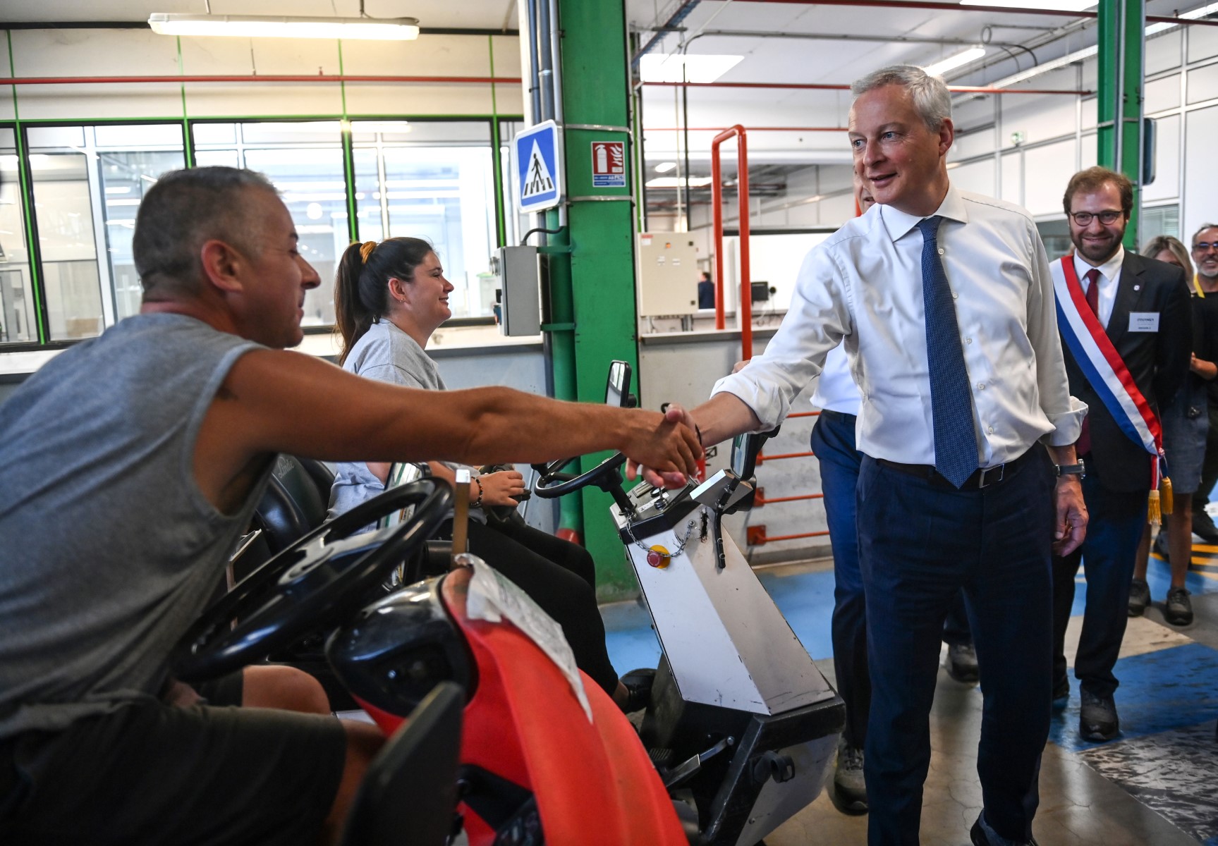 Le ministre français de l'Économie, des Finances et de la Souveraineté industrielle et numérique, Bruno Le Maire (au centre), est accueilli lors de sa visite de l'entreprise française Groupe Fournier à Thones, dans l'est de la France, le 24 août 2023. (Photo Olivier Chassignole / AFP)