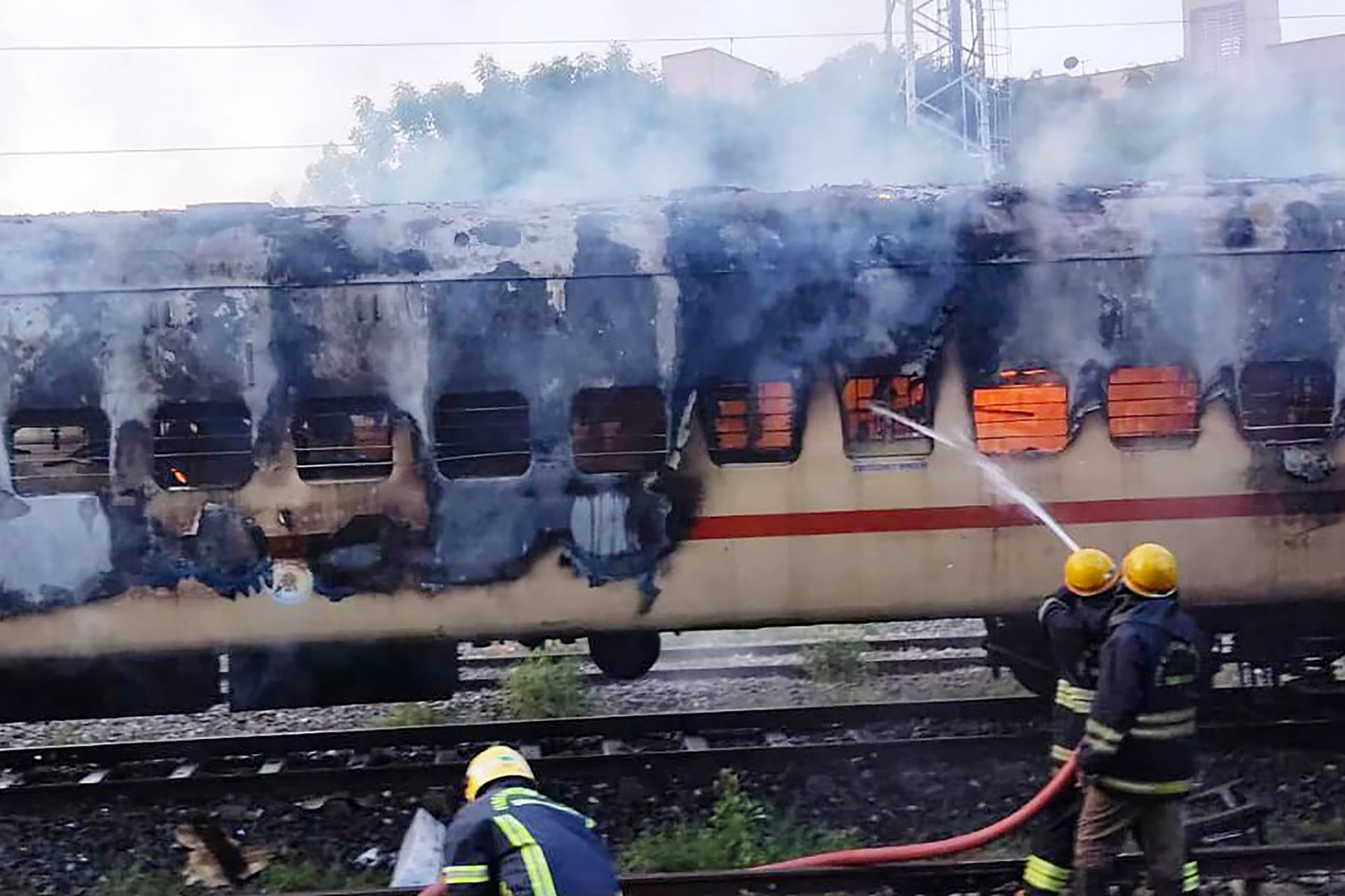 Des pompiers tentent d'éteindre un incendie qui s'est déclaré dans une voiture de train garée dans la gare de triage de Madurai, à Madurai, le 26 août 2023. (Photo par AFP)