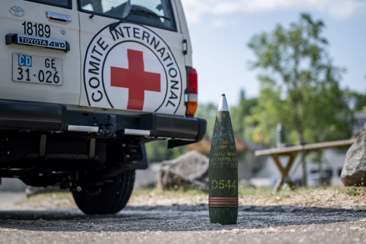 Un obus factice est vu à côté d'une voiture portant le signe du Comité international de la Croix-Rouge (CICR) lors d'une présentation à la presse de l'utilisation de drones dans le travail humanitaire à Avully, près de Genève, le 7 juin 2023. (Photo par Fabrice COFFRINI / AFP)