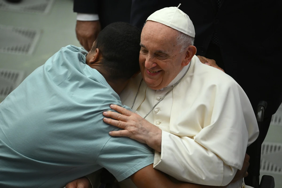 Le pape François embrasse un pèlerin lors de l'audience générale hebdomadaire le 9 août 2023 à la salle Paul-VI au Vatican. (Photo Filippo Monteforte / AFP)
