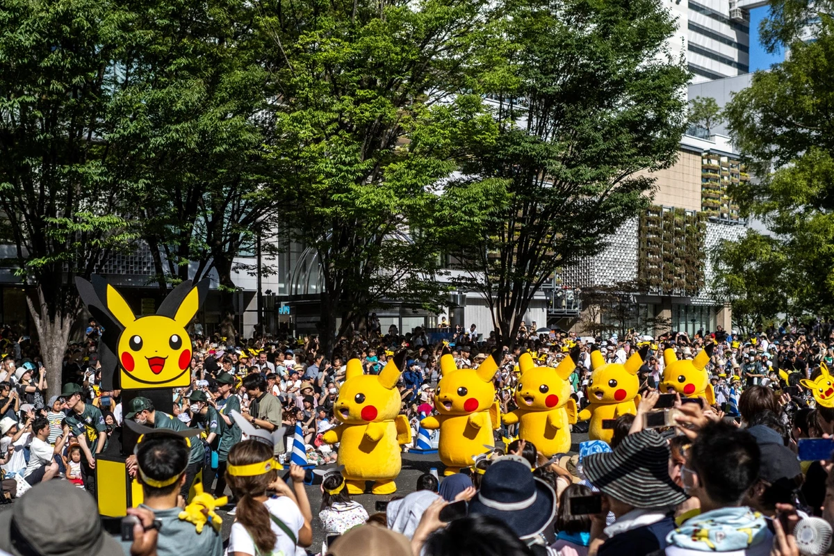 Des gens regardent la parade de Pikachu qui fait partie des Championnats du monde Pokémon 2023, au Grand Mall Park à Yokohama, le 11 août 2023. (Photo de Philip FONG / AFP)