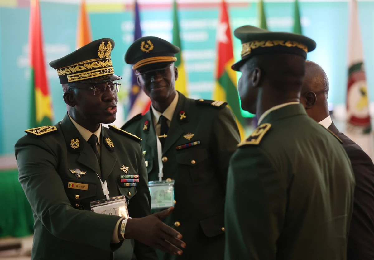 Des membres des forces armées sénégalaises discutent en marge de la session extraordinaire des chefs d'État et de gouvernement de la Communauté économique des États de l'Afrique de l'Ouest (CEDEAO) à Abuja, le 10 août 2023. (Photo Kola Sulaimon / AFP)