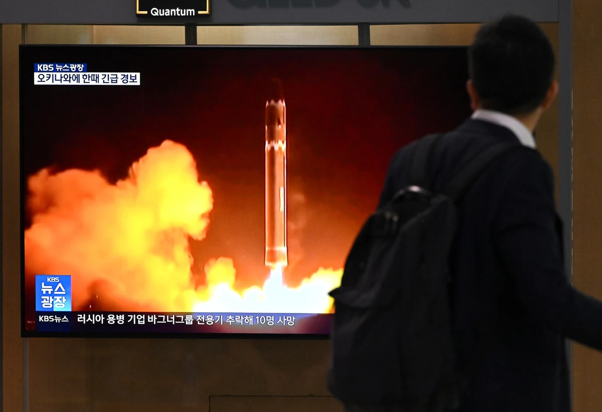 Un homme passe devant un écran de télévision diffusant des images d'un essai de missile nord-coréen, dans une gare de Séoul, le 24 août 2023. (Photo Jung Yeon-je / AFP)