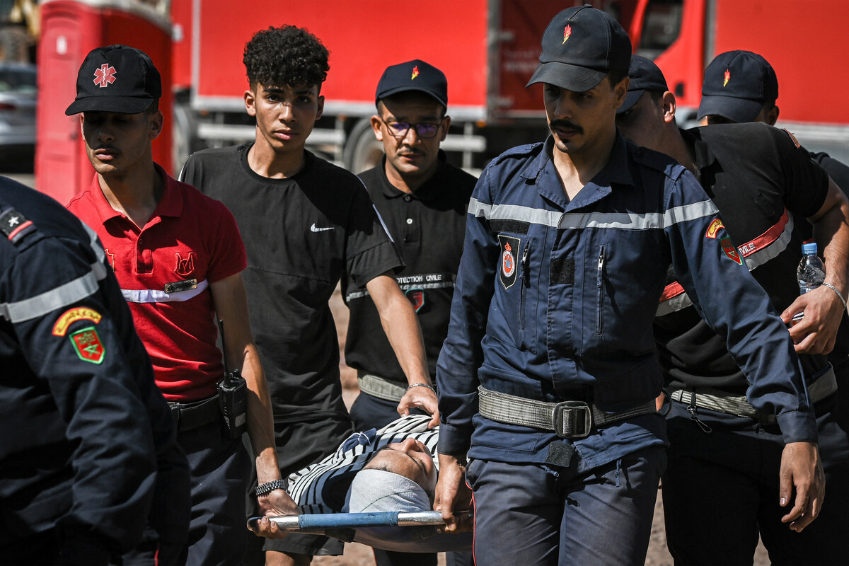 Des membres de la protection civile transportent une victime du tremblement de terre du 8 septembre dans un hôpital militaire de campagne dans le village d'Asni près de Moulay Brahim dans la province d'al-Haouz dans les montagnes du Haut Atlas du Maroc central, le 11 septembre 2023. (Photo Philippe Lopez AFP)