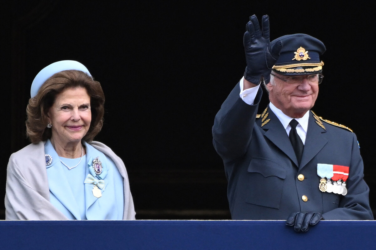 La reine Silvia de Suède (G) et le roi Carl XVI Gustaf de Suède se saluent depuis le balcon après la relève de la garde royale dans la cour extérieure pour le 50e anniversaire de l'accession au trône du roi Carl XVI Gustaf au Palais royal de Stockholm, Suède, le 15 septembre 2023. (Photo Jonathan Nackstrand AFP)
