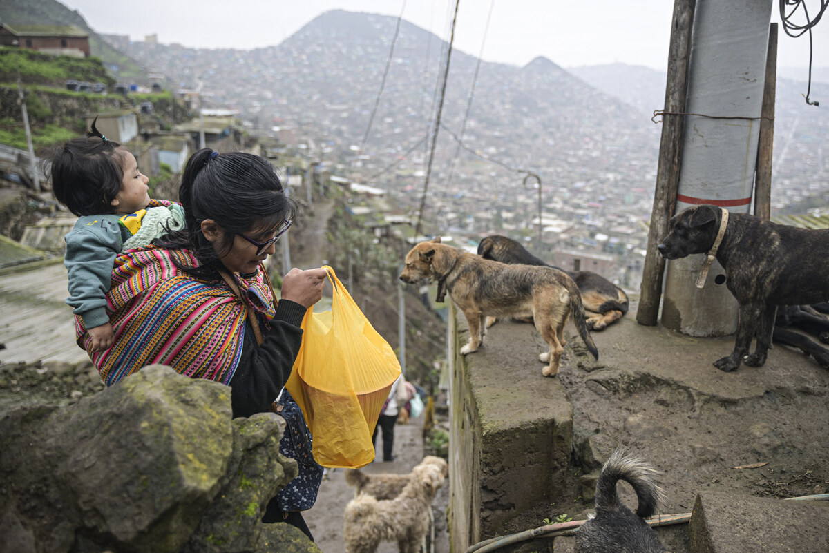 Une femme repart avec son déjeuner d’une soupe populaire du district de Villa Maria del Triunfo, dans la banlieue sud de Lima, le 21 septembre 2023. (Photo par Ernesto Benavides AFP)