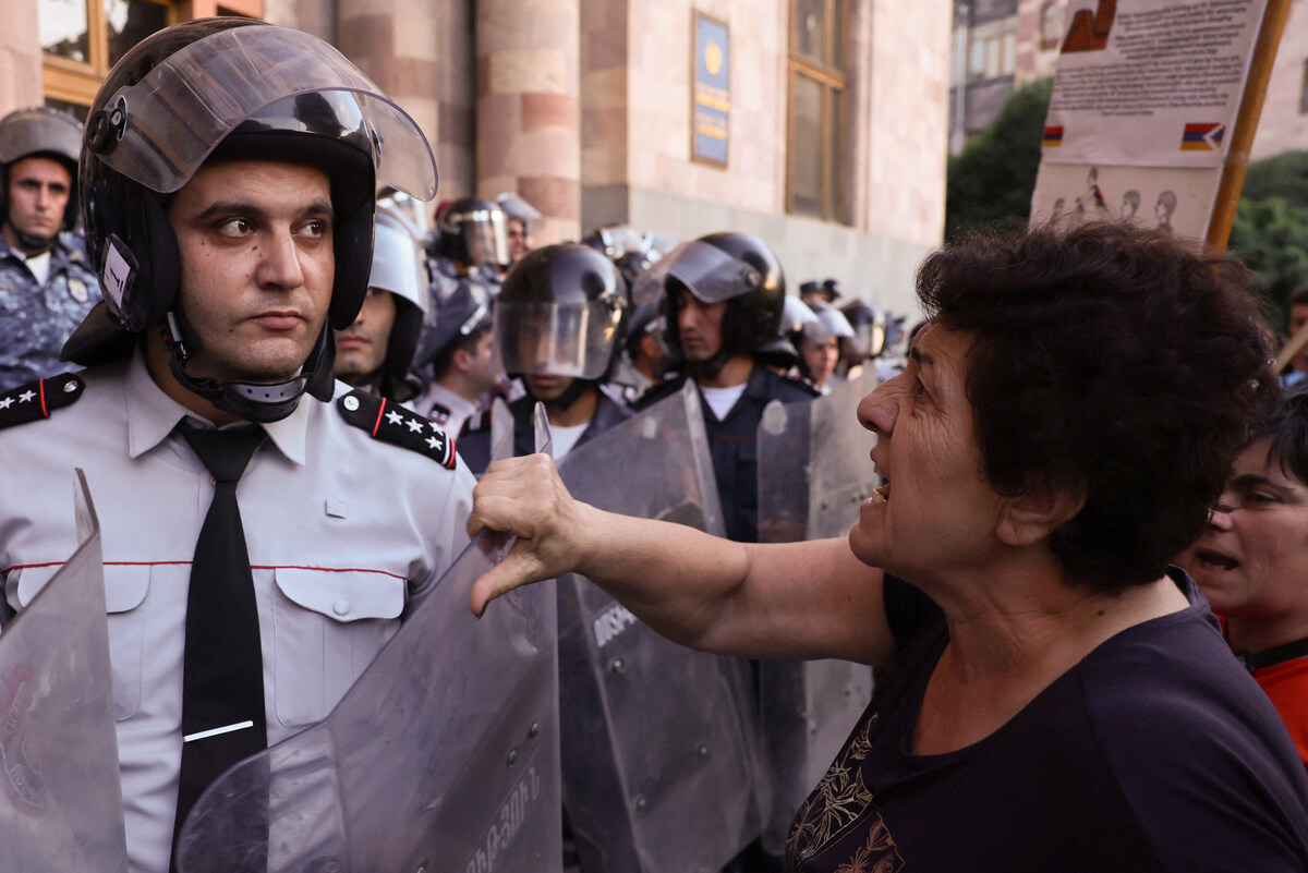 Une femme (à droite) parle avec des officiers de police arméniens lors d'une manifestation devant le siège du gouvernement à Erevan le 21 septembre 2023, suite aux opérations militaires azerbaïdjanaises contre les forces séparatistes arméniennes dans le Haut-Karabakh. (Photo Alain Jocard / AFP)