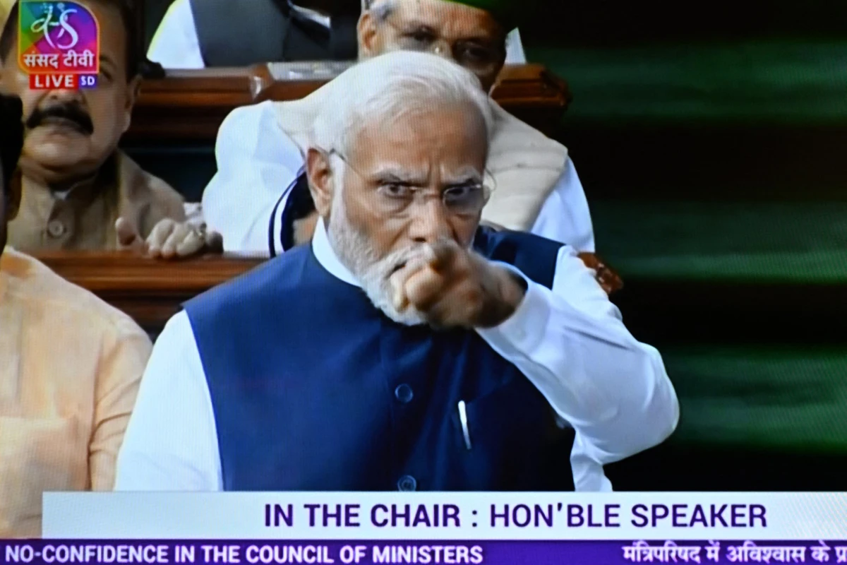Sur cette capture d'écran, le Premier ministre indien Narendra Modi (à droite) apparaît sur un écran de télévision alors qu'il s'adresse à la chambre basse Lok Sabha à New Delhi le 10 août 2023, en réponse à la motion de défiance de l'opposition à l'encontre du gouvernement NDA. (Photo Arun Sankar AFP)
