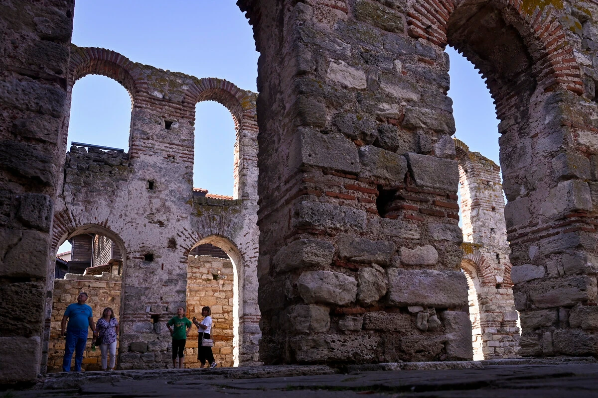 Cette photo prise le 13 septembre 2023 montre des touristes visitant les vestiges de l'église de Sainte Sofia dans la ville antique de Nessebar, site classé au patrimoine de l'Unesco. (Photo Nikolay Doychinov AFP)