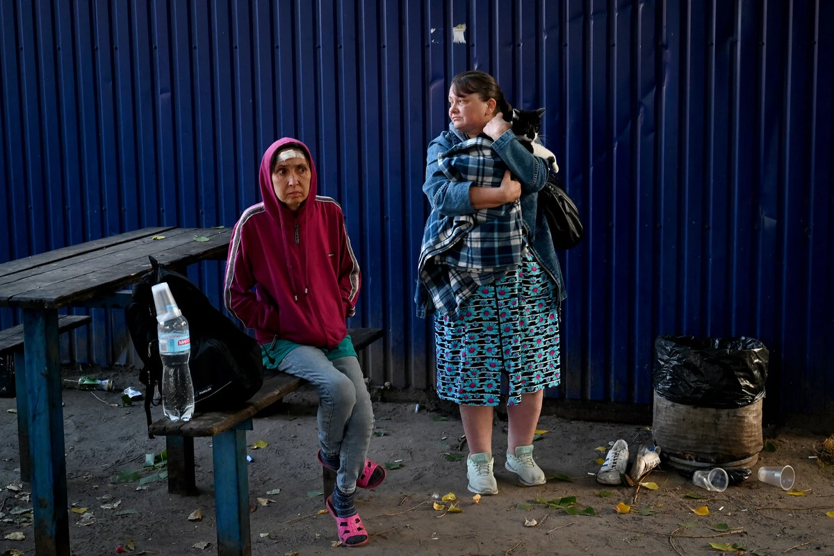 Des habitants attendent près d'une zone industrielle de la capitale ukrainienne, Kiev, après une attaque massive de missiles contre l'Ukraine, le 21 septembre 2023. Photo par Sergei Supinsky AFP)