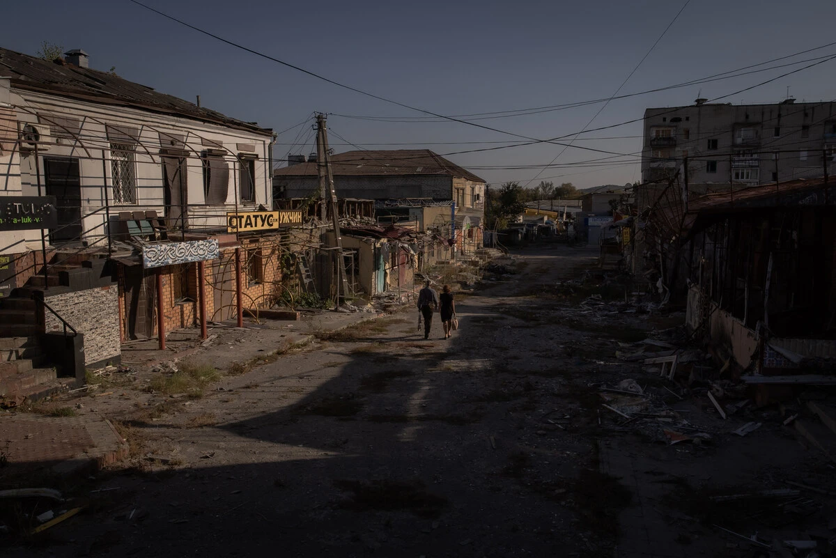 Des habitants passent devant des magasins et des bâtiments endommagés à Kupiansk, dans la région de Kharkiv, le 28 septembre 2023, lors de l'invasion russe de l'Ukraine. (Photo Roman Pilipey / AFP)