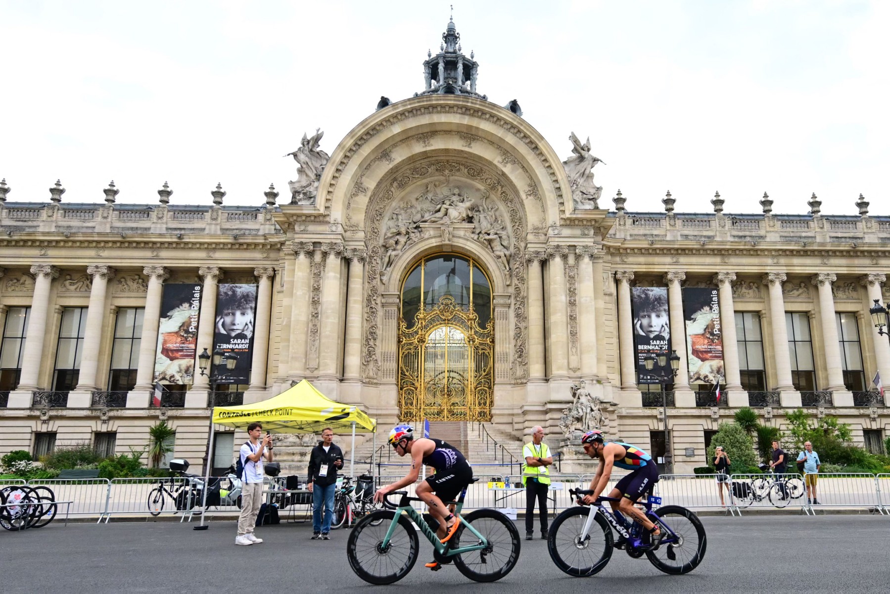 Des athlètes de triathlon roulent avec le Petit Palais en arrière-plan lors de l'épreuve test des Jeux olympiques mondiaux de triathlon 2023 pour les hommes à Paris, le 18 août 2023. (Photo Emmanuel Dunand, Pool AFP)