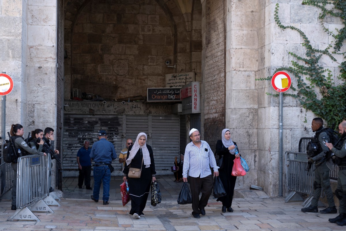 Des musulmans palestiniens passent devant les forces de sécurité israéliennes stationnées à la porte de Damas, alors que les fidèles quittent la vieille ville de Jérusalem après les prières du vendredi midi, le 3 novembre 2023. (Photo par Yuri Cortez / AFP)