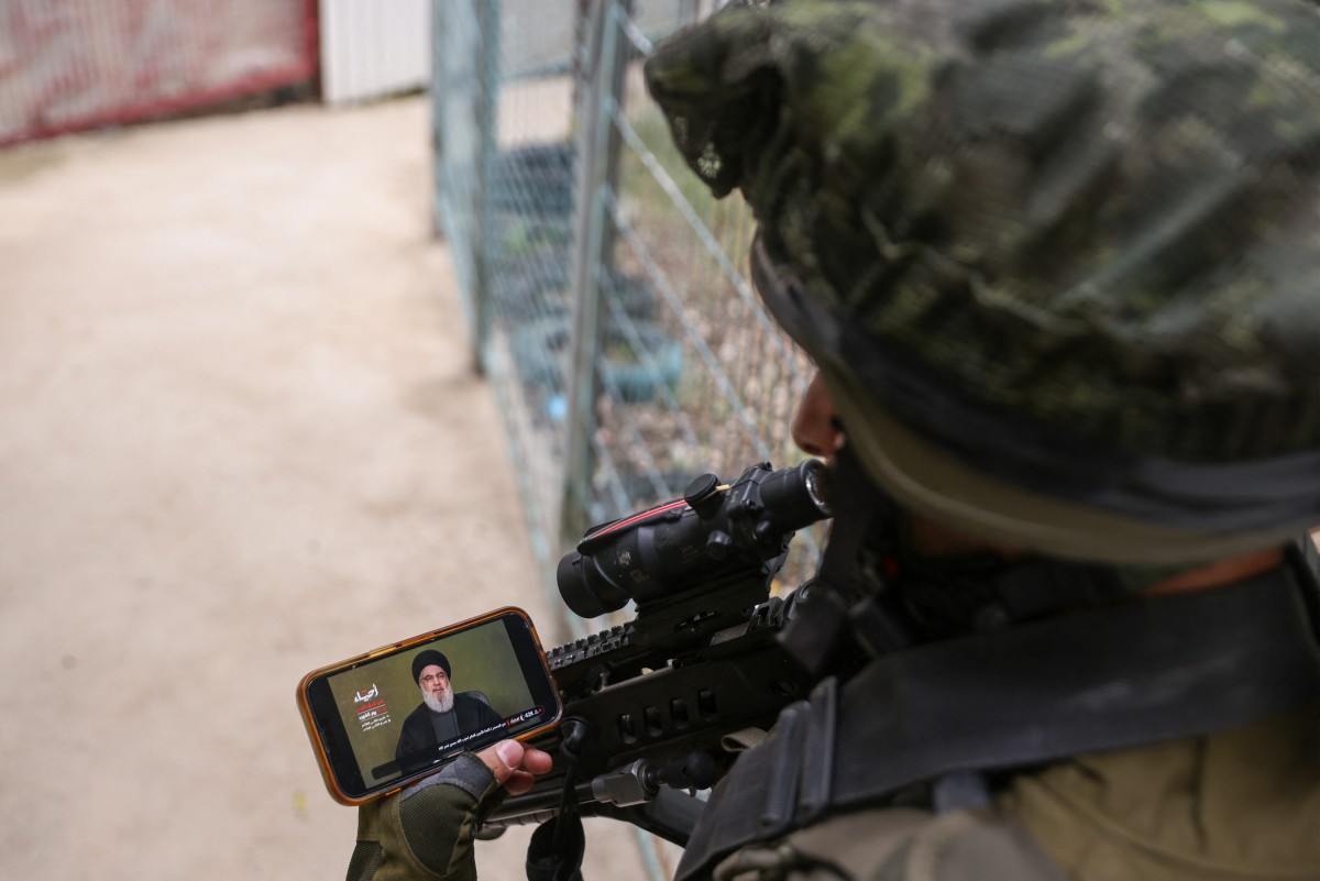 Un soldat israélien regarde un discours télévisé du chef du mouvement chiite Hezbollah, Hassan Nasrallah, près de la frontière israélienne avec le Liban, le 11 novembre 2023, dans un contexte de tensions transfrontalières croissantes entre le Hezbollah et Israël, alors que les combats se poursuivent dans le sud avec les militants du Hamas dans la bande de Gaza. (Photo Jalaa Marey AFP)